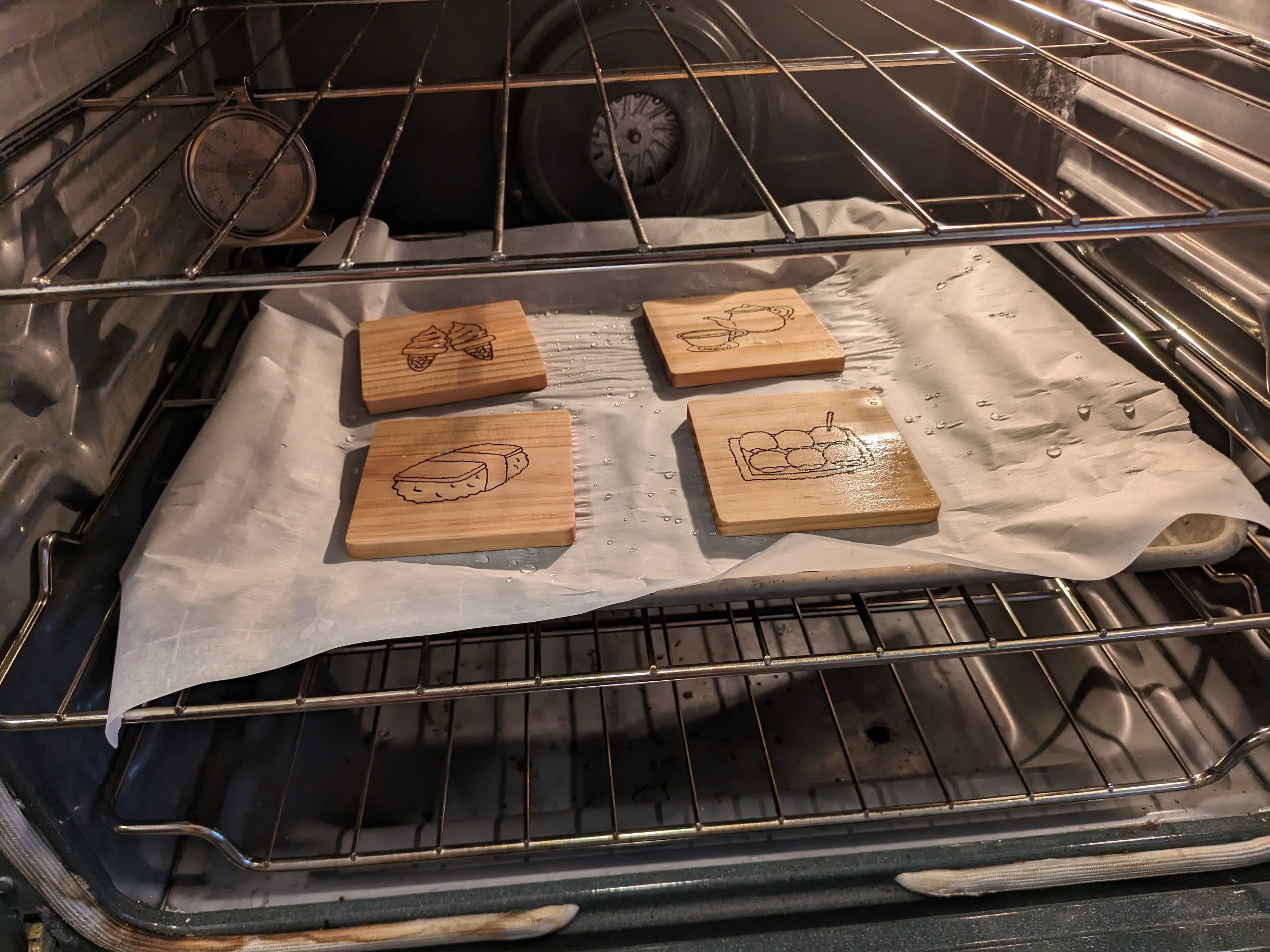 Image showing wet wood coasters on a baking sheet in the oven.