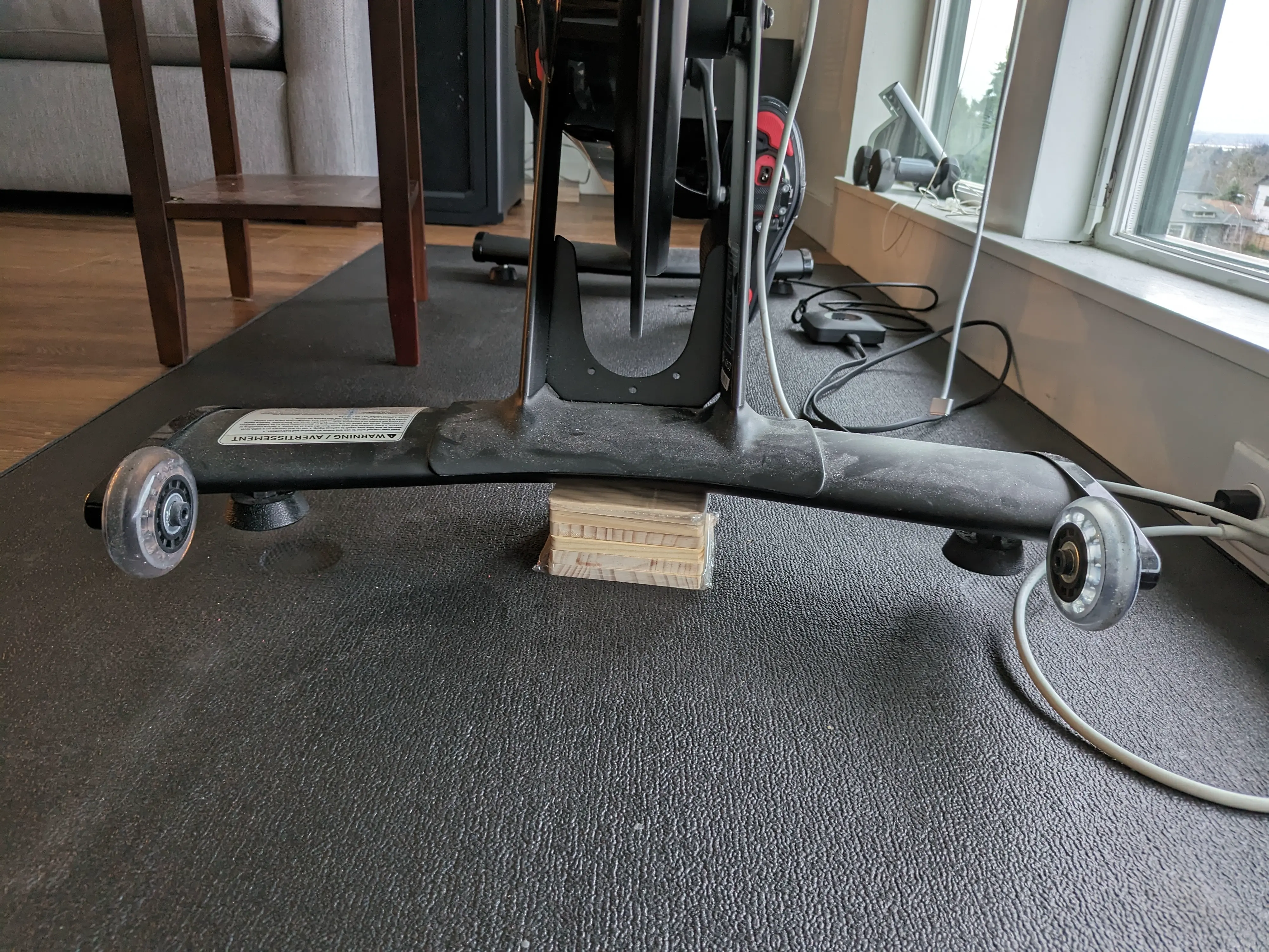 Image showing the coasters in a pile, supporting the weight of a Peloton stationary cycling machine.